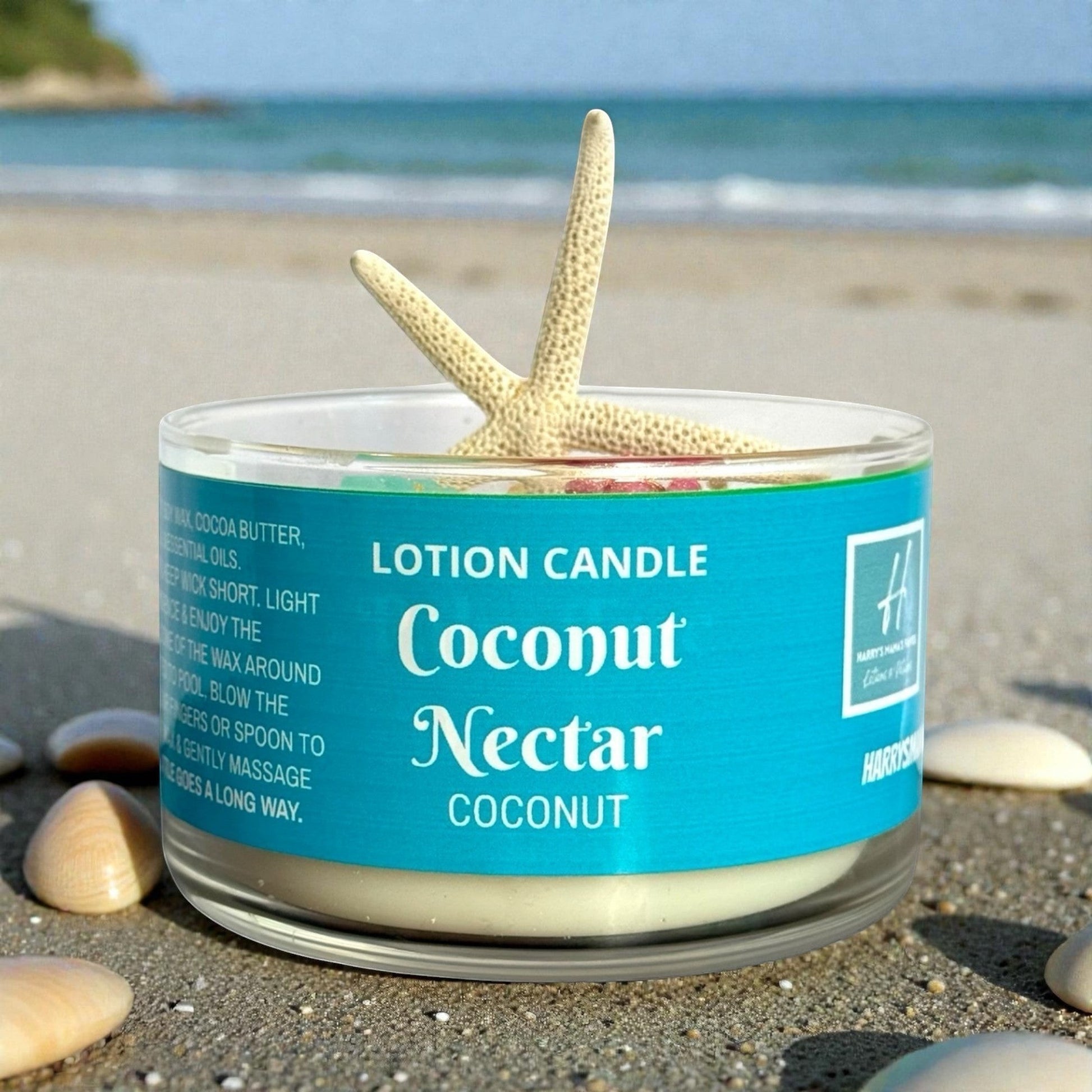 Harry’s Mama’s Faves: Lotions & Potions Coconut Nectar lotion candle with starfish and seashell wax embeds on sand.