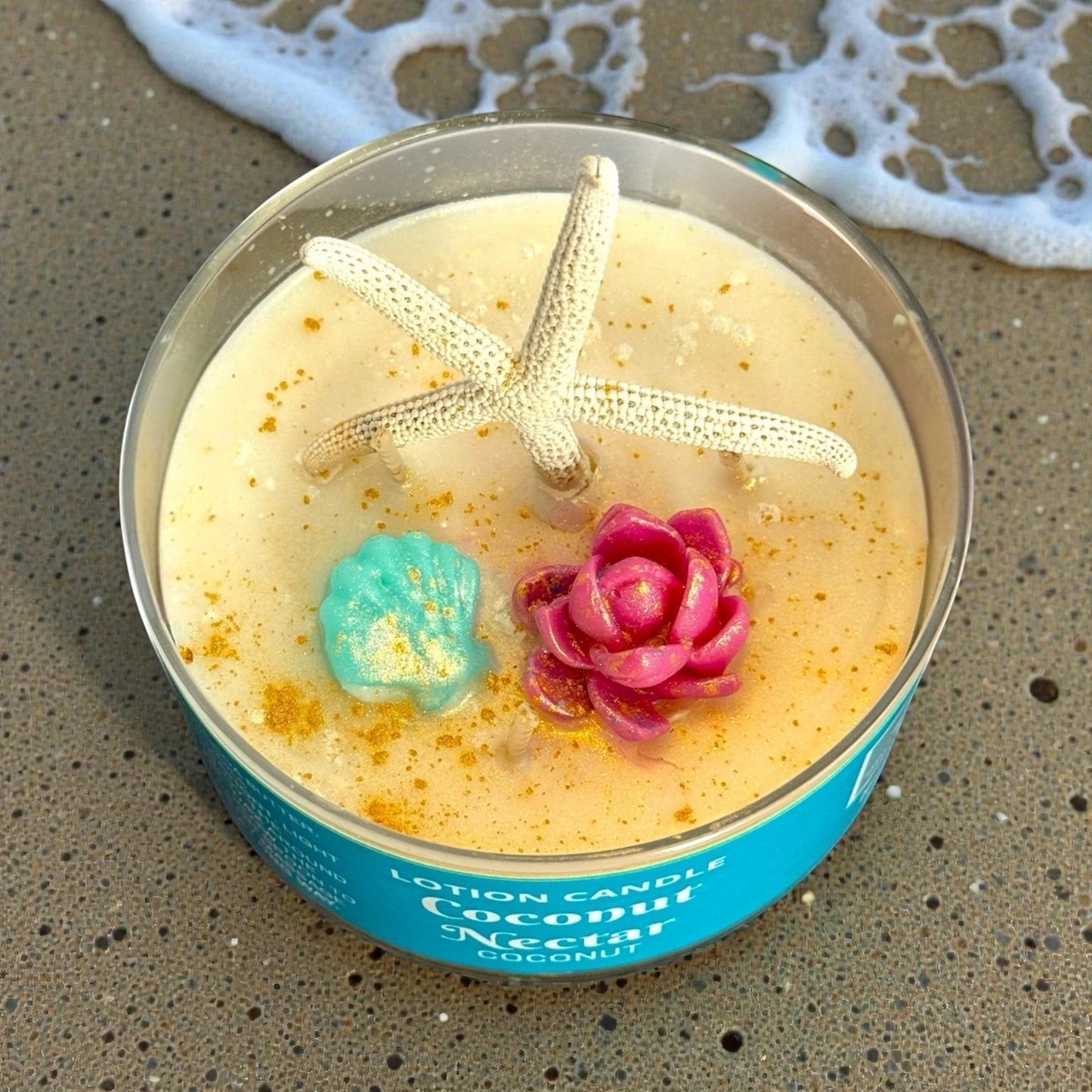 Harry’s Mama’s Faves: Lotions & Potions coconut nectar lotion candle with starfish, seashell, and flower wax embeds.