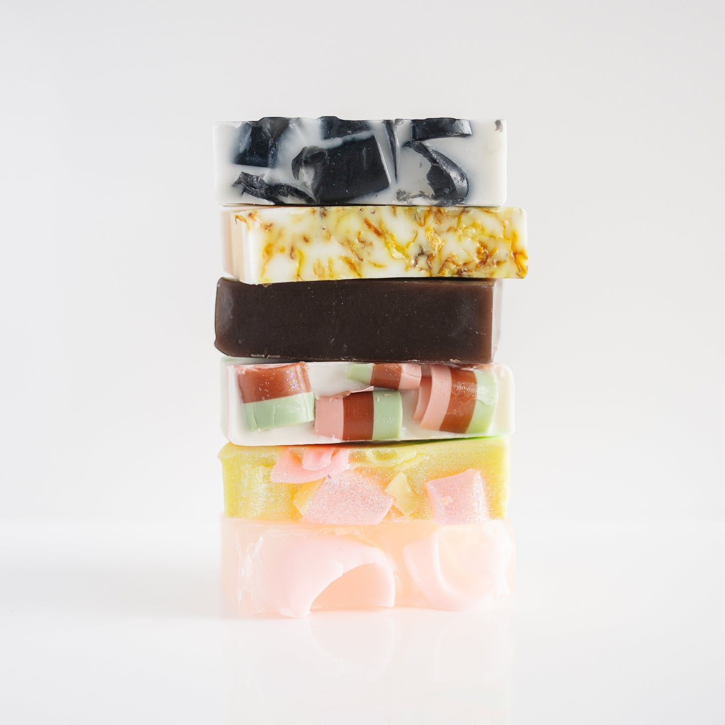 Harry’s Mama’s Faves: Lotions & Potions artisan handmade bar soap stack featuring various colors and textures.