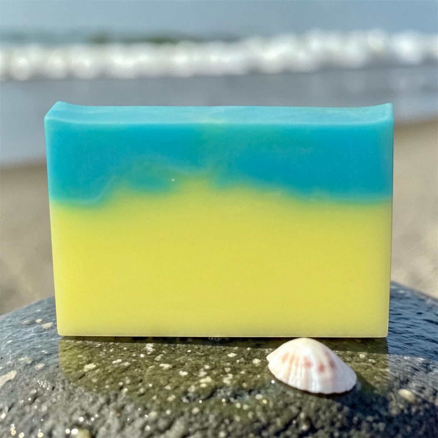 Harry’s Mama’s Faves: Lotions & Potions Hawaiian Coconut artisan handmade bar soap with blue and yellow layers on a rock