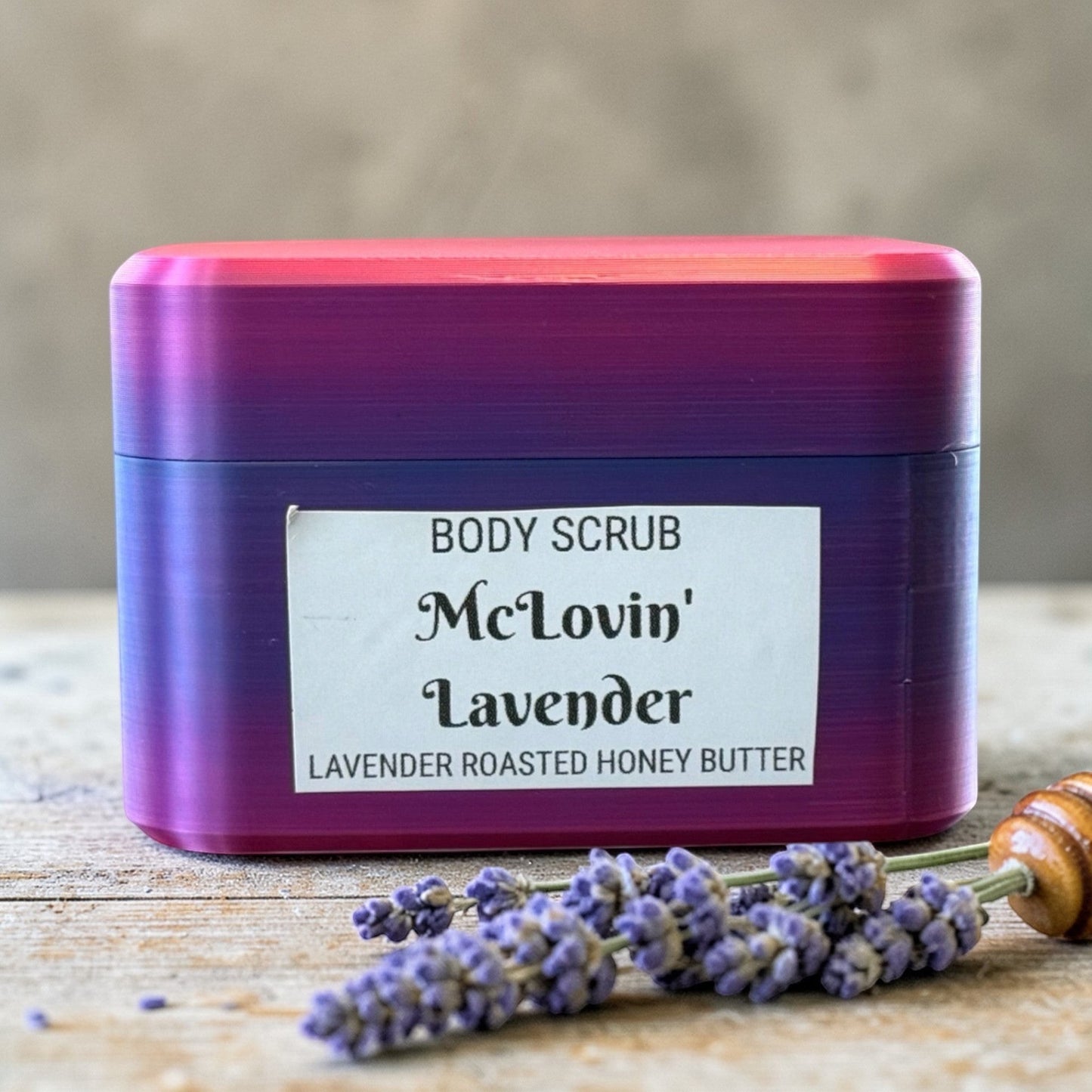 Harry’s Mama’s Faves: Lotions & Potions body scrub in a purple and pink gradient container with lavender sprigs.