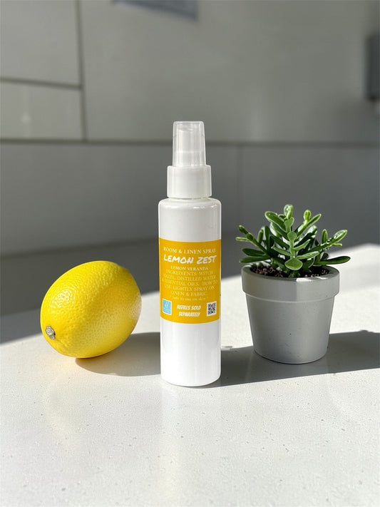 Harry’s Mama’s Faves: Lotions & Potions Lemon Zest room and linen spray bottle next to a fresh lemon and small plant.