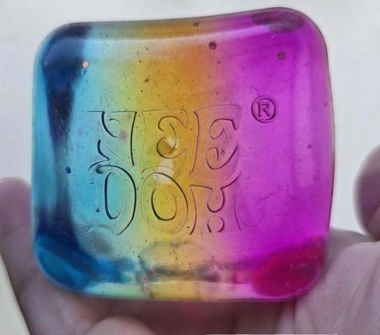Harry’s Mama’s Faves: Lotions & Potions Nee Doh Nice Cube sensory toy with a vibrant blue, yellow, and pink gradient.