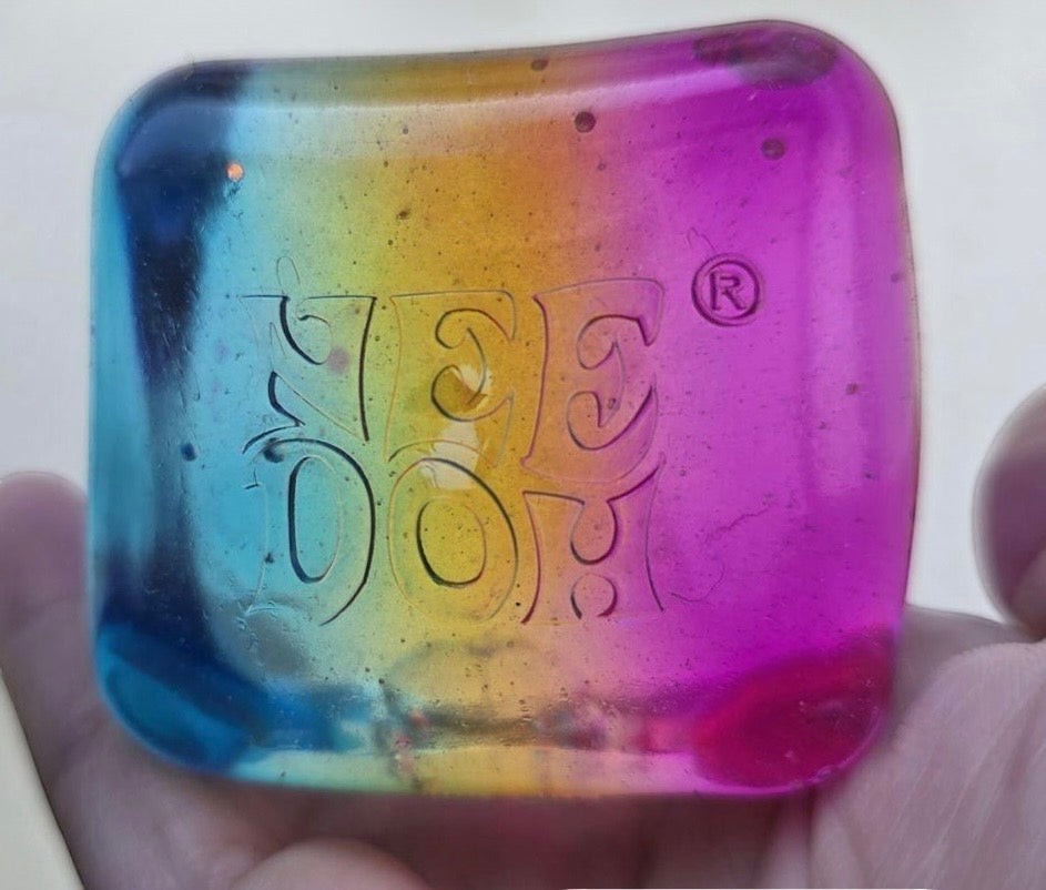Harry’s Mama’s Faves: Lotions & Potions Nee Doh Nice Cube sensory fidget toy with a vibrant blue, yellow, and pink gradient.