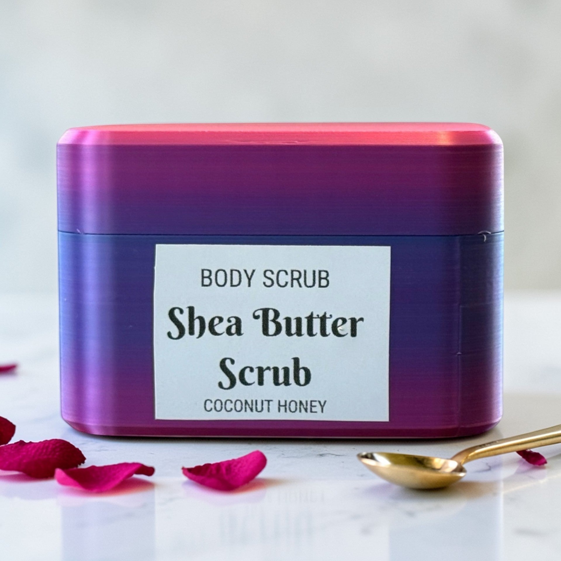 Harry’s Mama’s Faves: Lotions & Potions shea butter body scrub in a purple and pink gradient container with rose petals.