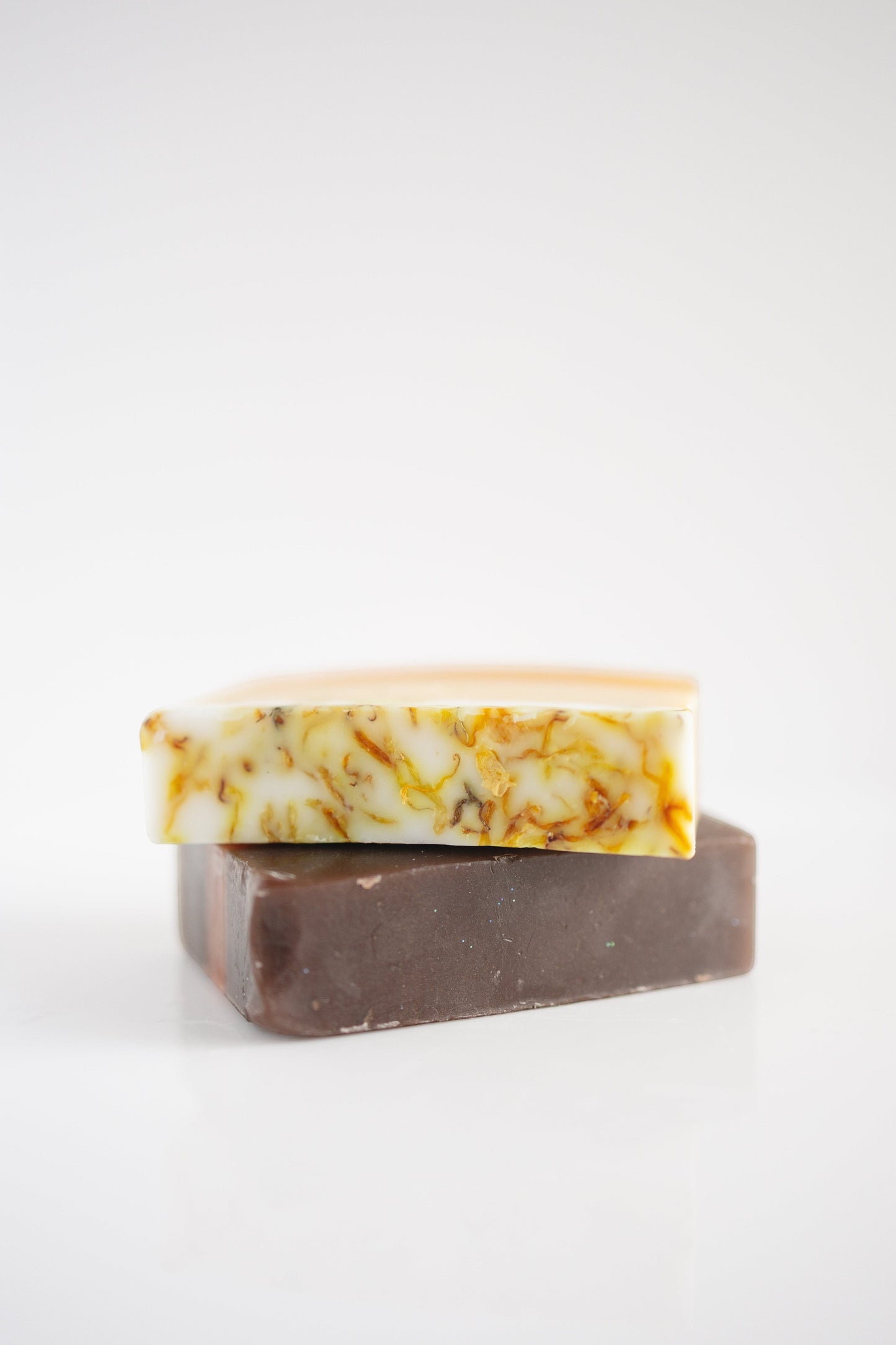 Harry’s Mama’s Faves: Lotions & Potions sunflower honey calendula artisan bar soap stacked on a dark brown soap bar.