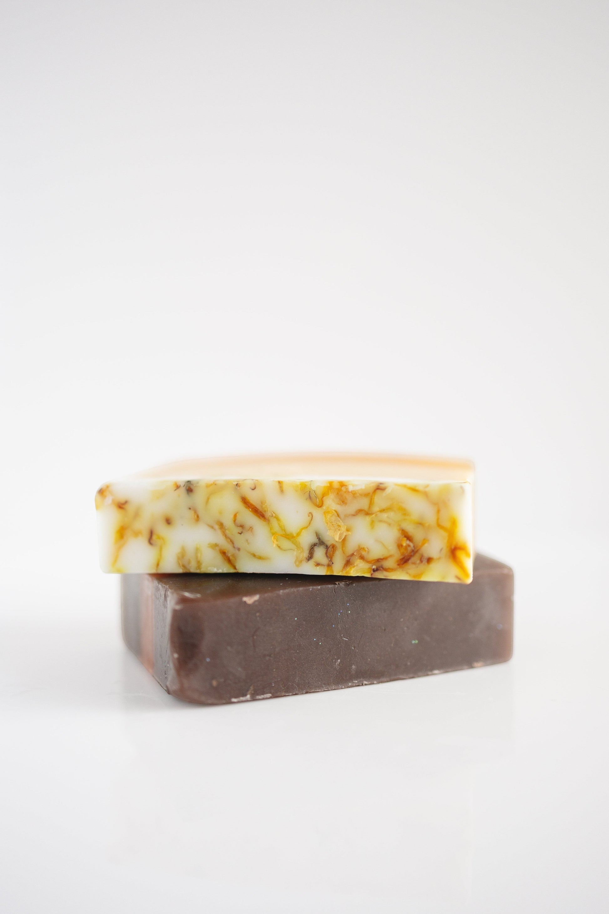 Harry’s Mama’s Faves: Lotions & Potions sunflower honey calendula artisan bar soap stacked on a dark brown soap bar.